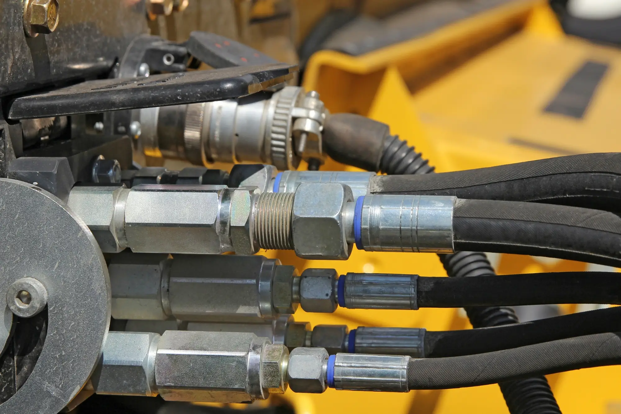 Close-up of interconnected hydraulic hoses and fittings on heavy machinery in Gauteng. M Power Transfer expert hydraulic repairs.